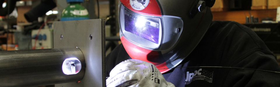 Welder at work, used as context for coordinated manufacturing